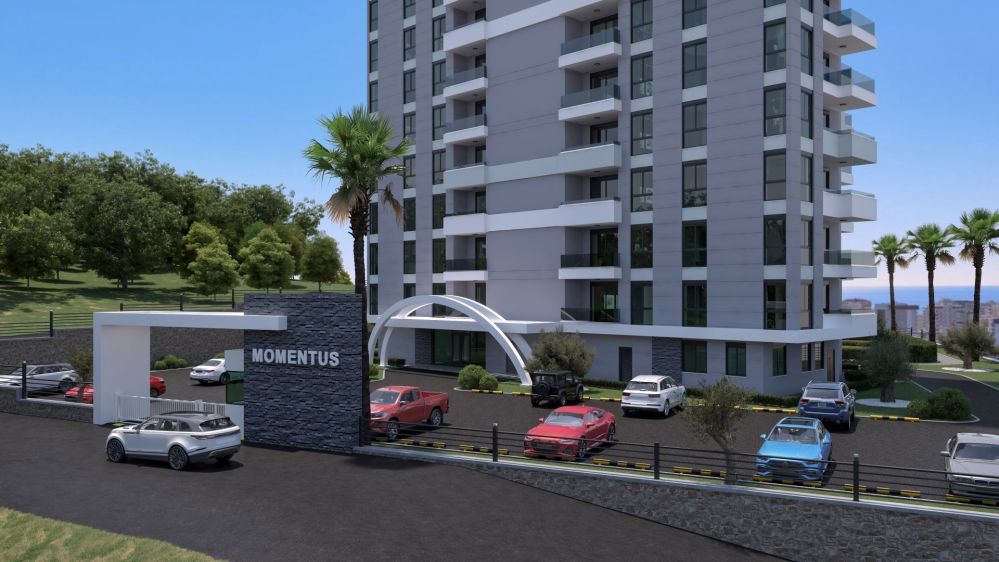 The main entrance welcomes residents with stylish architecture, spacious parking areas, and a modern aesthetic design.Modern Residential Project in Mahmutlar Alanya