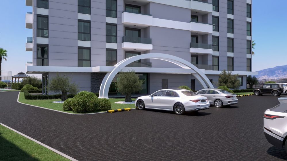 Geniş otopark alanı, modern giriş kapısı ve düzenli yaya yollarıyla site içi ulaşım kolaylığı sağlanıyor.Alanya Mahmutlar’da Modern Konut Projesi