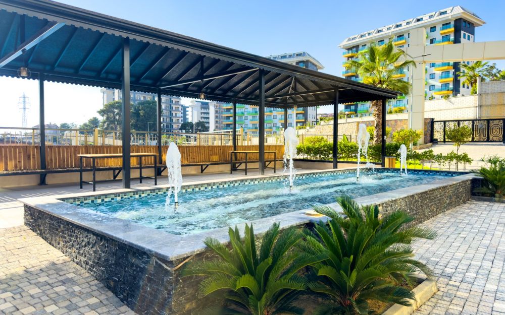 Вид с высоты на современные жилые блоки, расположенные недалеко от моря и окружённые природой. Роскошные и комфортные резиденции на побережье Средиземного моря