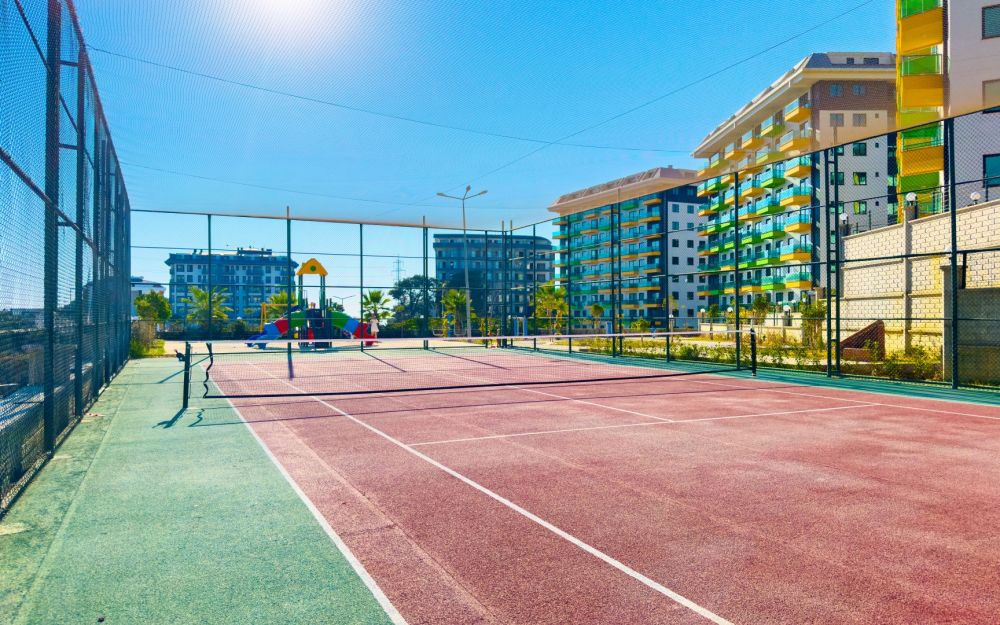 Современный теннисный корт на территории комплекса для спорта и активного досуга. Роскошные и комфортные резиденции на побережье Средиземного моря