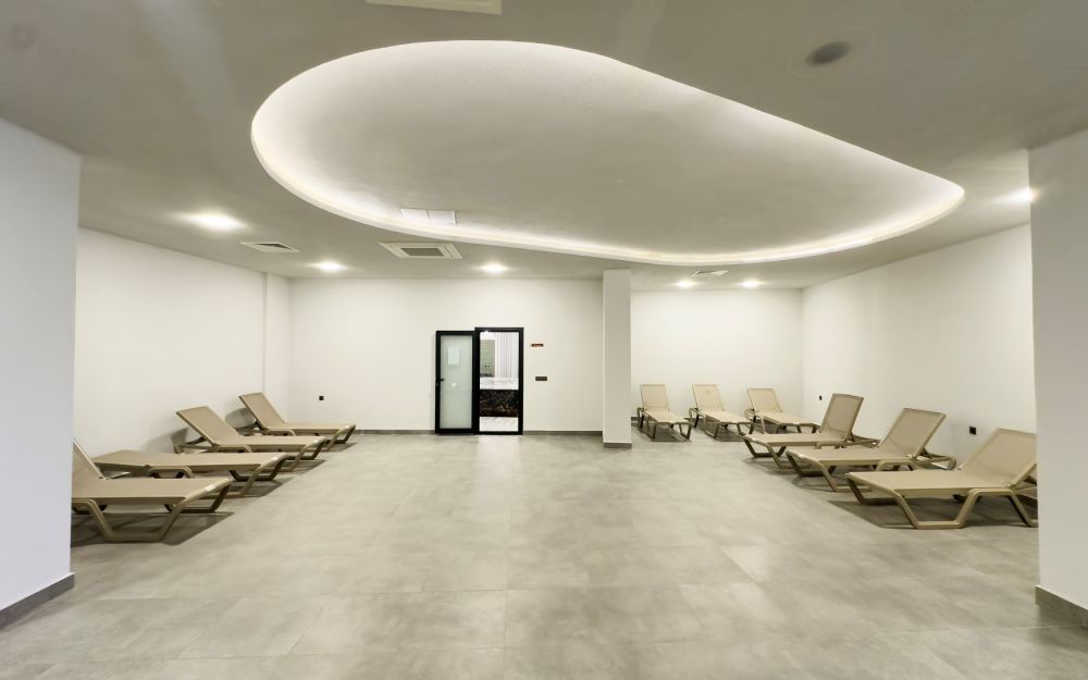 Просторная лаунж-зона с шезлонгами и спокойными бежевыми тонами. Роскошные и комфортные резиденции на побережье Средиземного моря