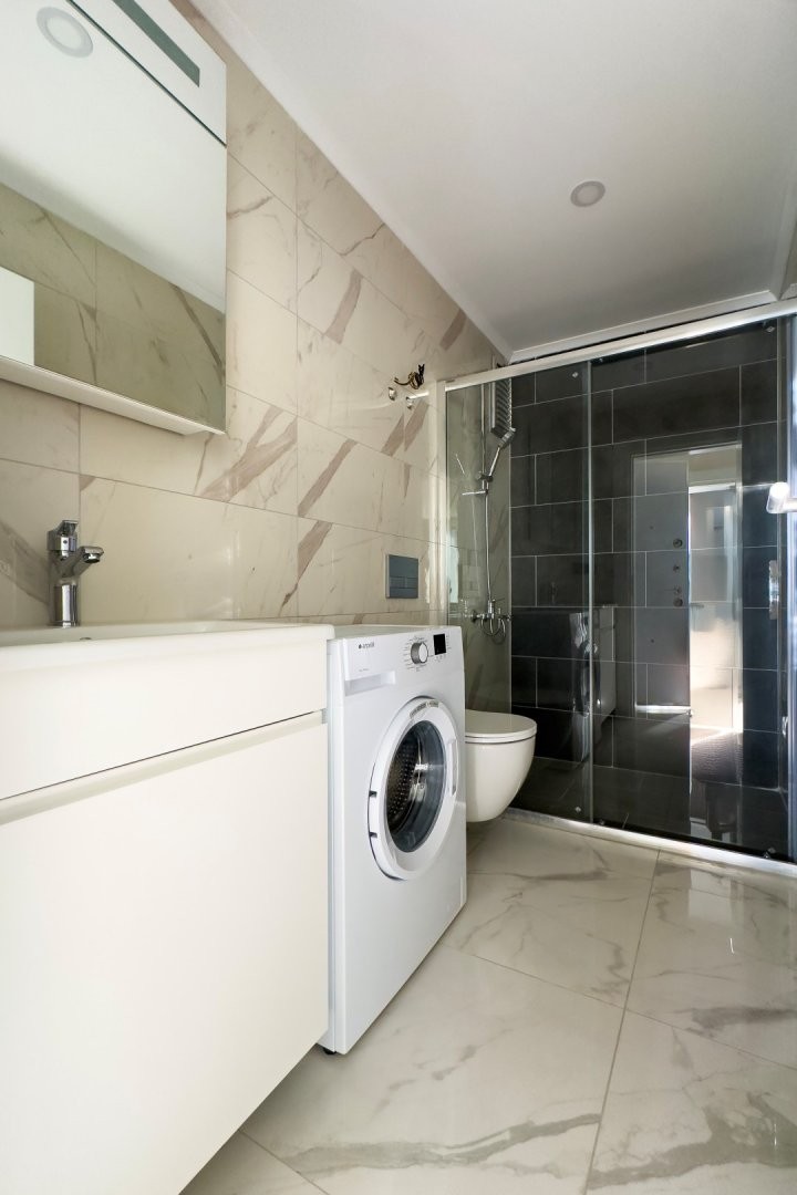 Tam donanımlı banyo, modern seramik ve duş kabiniyle tasarlandı.Akdeniz Kıyısında Lüks ve Konforlu Rezidans Daireler