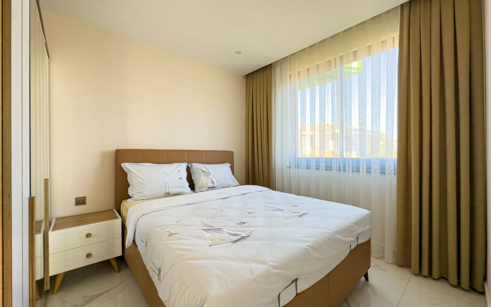 Светлая спальня с большими окнами, минималистичной мебелью и качественной отделкой. Роскошные и комфортные резиденции на побережье Средиземного моря