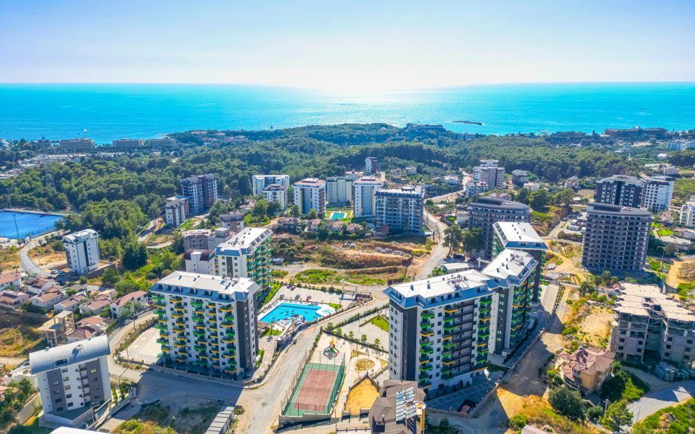 Панорамный вид на жилой комплекс класса люкс, окружённый зеленью и Средиземным морем. Роскошные и комфортные резиденции на побережье Средиземного моря