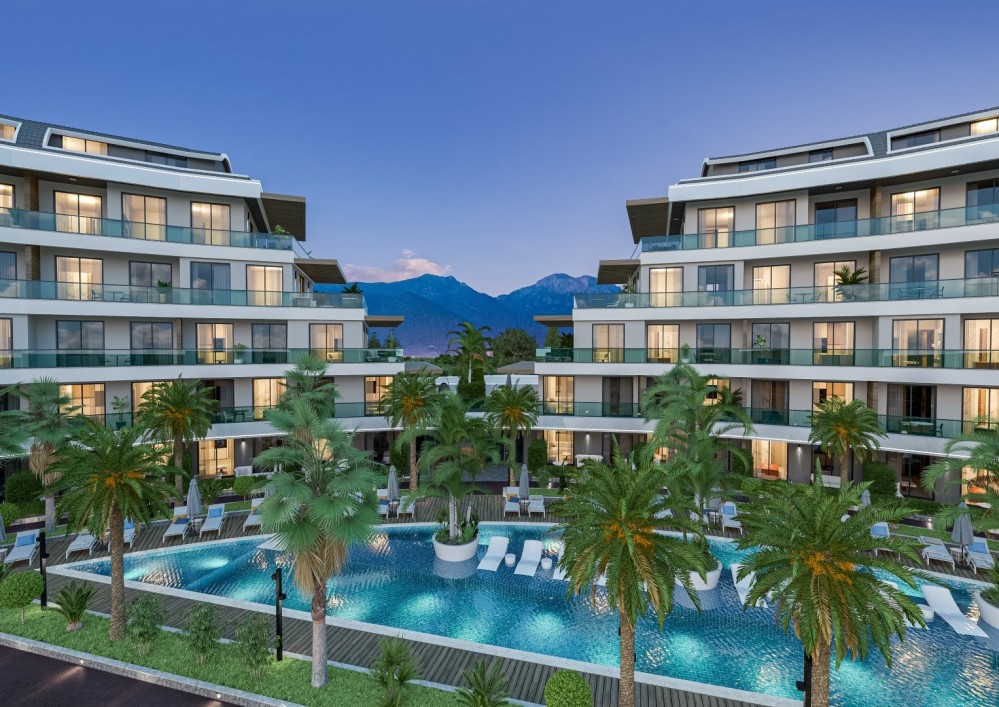 Akşam ışıklandırmasıyla öne çıkan modern mimari ve etkileyici havuz manzarası.Alanya Oba’da Ultra Lüks Konut Projesi
