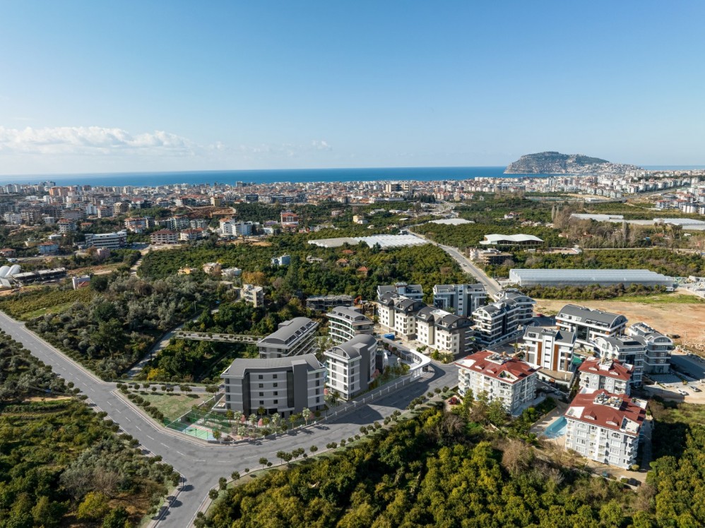 Projenin doğal çevre ve şehir manzarasıyla birleşen üstten genel görünümü.Alanya Oba’da Ultra Lüks Konut Projesi
