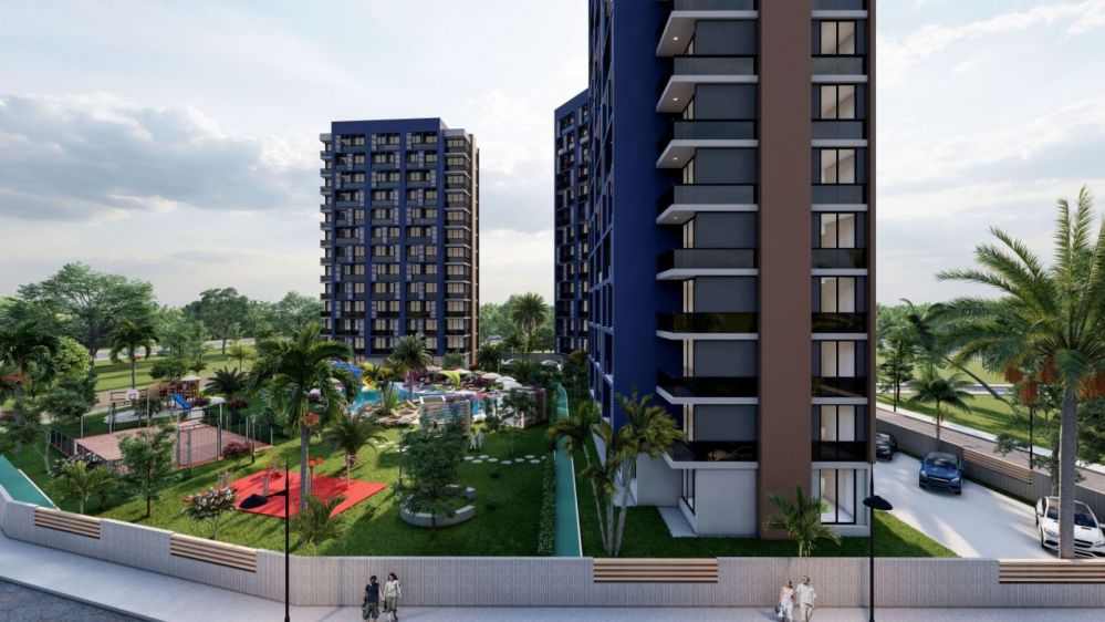Doğayla iç içe tasarlanmış havuz alanı, sosyal donatılar ve modern rezidans bloklarının birleştiği site görünümü.Mersin – Tece Bölgesinde Yatırıma Uygun Lüks Konut Projesi